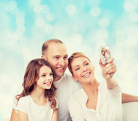 Image showing happy family with camera at home