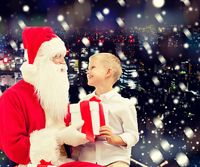 Image showing smiling little boy with santa claus and gifts