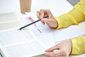 Image showing close up of female hands with book and notebooks