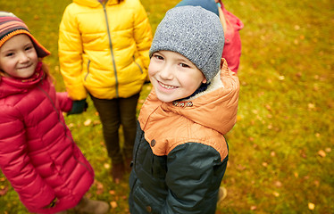 Image showing children holding hands and playing in autumn park