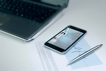 Image showing close up of smartphone, laptop and pen on table