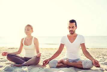 Image showing smiling couple making yoga exercises outdoors