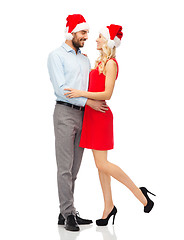 Image showing happy couple in santa hats hugging