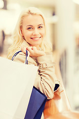 Image showing happy young woman with shopping bags in mall