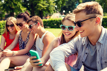 Image showing smiling friends with smartphone making selfie