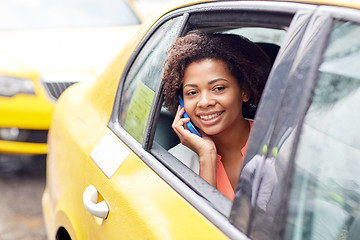 Image showing happy african woman calling on smartphone in taxi