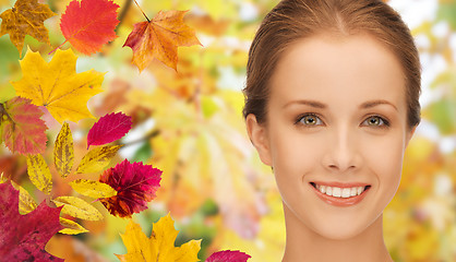 Image showing beautiful young woman face over autumn leaves