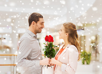 Image showing happy young couple with flowers in mall