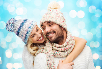 Image showing happy couple in winter clothes hugging over lights