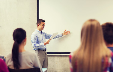 Image showing group of students and smiling teacher with notepad