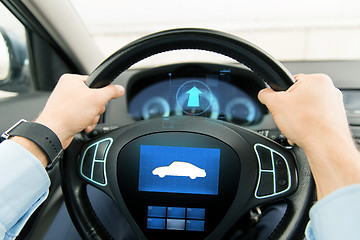 Image showing close up of man driving car with icon on computer