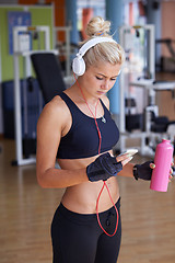 Image showing woman with headphones in fitness gym