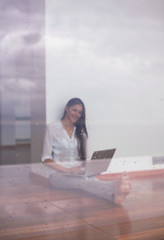 Image showing relaxed young woman at home working on laptop computer