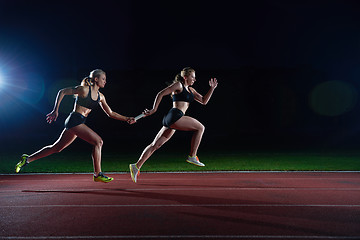 Image showing athletic runners passing baton in relay race