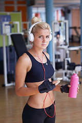 Image showing woman with headphones in fitness gym