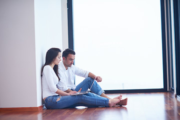 Image showing relaxed young couple working on laptop computer at home