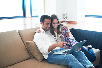 Image showing relaxed young couple working on laptop computer at home