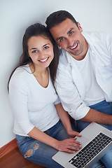 Image showing relaxed young couple working on laptop computer at home