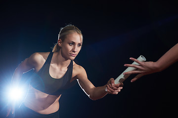 Image showing athletic runners passing baton in relay race