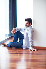 Image showing relaxed young man drink first morning coffee withh rain drops on