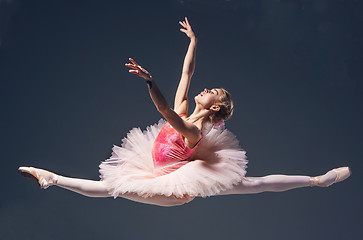 Image showing Beautiful female ballet dancer jumping on a gray background