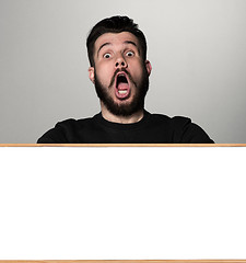 Image showing The surprised man and empty blank over gray background