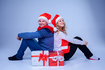 Image showing Lovely christmas couple sitting with presents