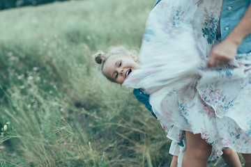 Image showing The young mother and daughter on green grass background 