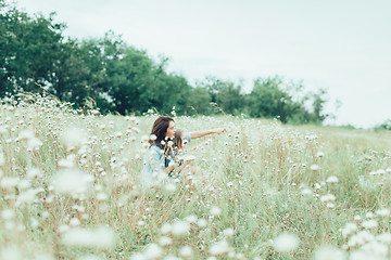 Image showing The young mother and daughter on green grass background 