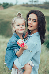 Image showing The young mother and daughter on green grass background 