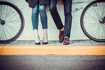 Image showing Young couple sitting on a bicycle opposite the city 