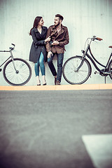 Image showing Young couple with a bicycle opposite city 