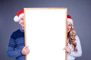 Image showing Christmas couple holding white board with empty copy space 