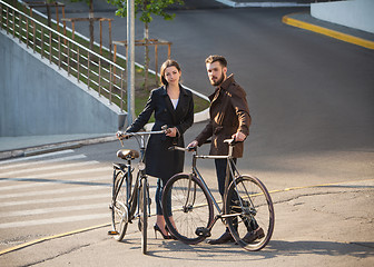 Image showing Young couple with on a bicycle opposite city 