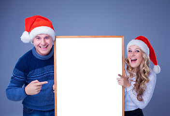 Image showing Christmas couple holding white board with empty copy space 