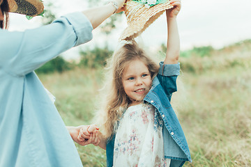 Image showing The young mother and daughter on green grass background 