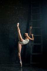 Image showing The beautiful ballerina posing against  dark background