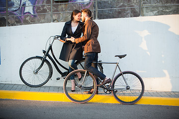 Image showing Young couple with a bicycle opposite city 