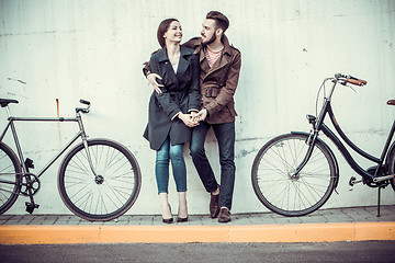 Image showing Young couple with a bicycle opposite city 