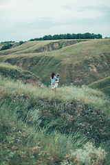 Image showing The young mother and daughter on green grass background 