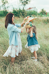 Image showing The young mother and daughter on green grass background 