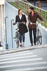 Image showing Young couple with a bicycle opposite city 