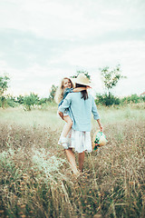 Image showing The young mother and daughter on green grass background 