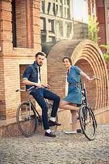 Image showing Young couple sitting on a bicycle opposite city 