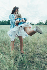 Image showing The young mother and daughter on green grass background 