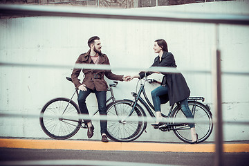 Image showing Young couple with a bicycle opposite city 