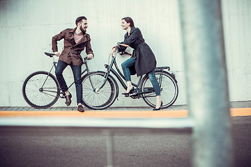 Image showing Young couple with a bicycle opposite city 