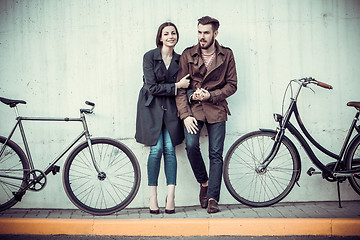 Image showing Young couple with a bicycle opposite city 