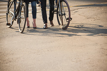 Image showing Young couple sitting on a bicycle opposite the city 