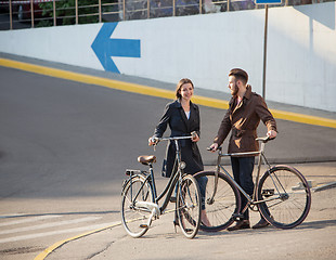 Image showing Young couple with on a bicycle opposite city 